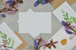 Composition on a table with blank sheet of paper to fill in the content, envelopes decorated with bouquets of small flowers. Top view. 