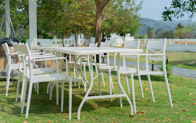  White dining table with chairs in the outdoor garden surround with garden green field.