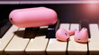 Pink bright headphones on piano keys, wireless technology