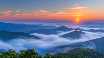 Poster - Misty mountain landscape with clouds, fog, and orange sunrise sky creating a serene morning view