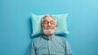 Elderly man sleeping on pillow isolated on pastel blue colored background Sleep deeply peacefully rest. Top above high angle view photo portrait of satisfied .senior wear blue shirt