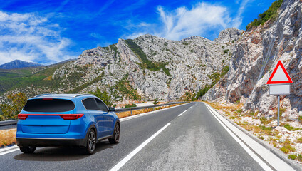 Wall Mural - Blue car on asphalt road. Asphalt road view in countryside at beautiful sunset