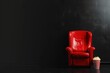 Red cinema armchair and bucket with popcorn, leisure and cinema concept, black background.