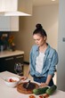 © SHOTPRIME STUDIO - Alone in the Kitchen: A Young Woman Enjoying a Gourmet Meal and a Glass of Wine in a Modern, Elegant Interior