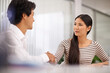 © Mikolette Moller/peopleimages.com - Business people, handshake and agreement with colleague for meeting or deal together at the office. Young asian man and woman holding or shaking hands in b2b, greeting or partnership at the workplace