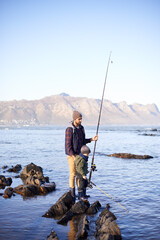 Sticker - Father, fishing rod and young boy on rocks, teaching and bonding for activity by ocean. Sea, teach and learn to fish for childhood development, winter and hobby together while on countryside vacation