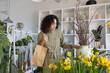 © ReeldealHD images - Female shopper choosing a plant in a florist to buy for a gift