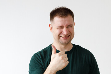 Canvas Print - A man in a green T-shirt shows emotions in front of the camera