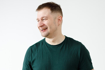 Wall Mural - A man in a green T-shirt shows emotions in front of the camera