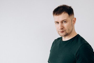 Canvas Print - A man in a green T-shirt shows emotions in front of the camera