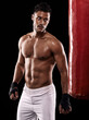 © Duncan M/peopleimages.com - Punching bag, man and boxing with fitness, training for a competition and wellness on a dark studio background. Person, model and guy with exercise and strong with workout and muscular with cardio