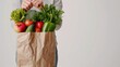 A woman holding grocery bags filled with vegetables inside grocery shopping bag