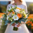 Bukiet ślubny z pomarańczowymi i białymi różami, gerberami i gałązkami eukaliptusa trzymany przez pannę młodą