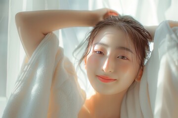 Wall Mural - beautiful young Asian woman in a white t-shirt smiling and relaxing on a bed in morning light