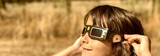 Fototapeta Miasta - A young girl looking at the sun during a solar eclipse on a country park, family outdoor activity