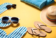 Beach Accessories On The Yellow Background - Sunglasses, Towel. Flip-flops And Striped Hat. Summer Is Coming Concept