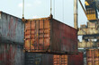 © Ivan - A metal container hanging on metal ropes in a port being unloaded or loaded