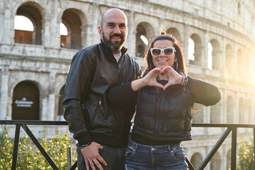 Wall Mural - Happy  Beautiful Tourists  couple traveling at Rome, Italy, taking a selfie portrait in front   of Colosseum.Visiting Italy - man and woman enjoying weekend vacation - Happy lifestyle concept 