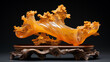 Imagined amber art mini sculpture seated on a dark walnut wood base in a decorative Chinese motif