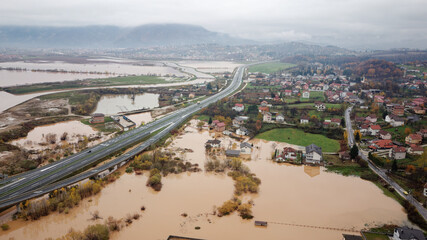 aerial drone view of torrential rain causes flash floods in residential areas. houses and roads surr