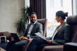 © Drazen - Happy black businessman and his female coworker working during their business travel.