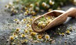 Chamomile tea leaves in a wooden scoop