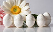 A group of white eggs with painted dot ornament on them are placed next to a daisy flowers. Easter, Pascha or Resurrection Sunday, Christian festival and cultural holiday concept