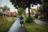 Fototapeta Sawanna - Junge passiert in Siegerpose mit seinem Rad das Ortsschild Coesfeld während einer Radreise durch das Münsterland, Kreis Coesfeld, Baumberge