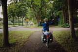 Fototapeta Sawanna - Junge passiert in Siegerpose mit seinem Rad das Ortsschild Münster während einer Radreise durch das Münsterland