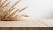 Light wooden table top with beige dry grass. Products presentation concept
