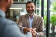 © Iftikhar alam - Two men, a businessman and a man in a suit, shaking hands in a professional setting, Professional man happily concluding a successful business deal, AI Generated