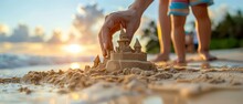 Some People Are Playing With A Sand Castle On The Beach. Generative AI.