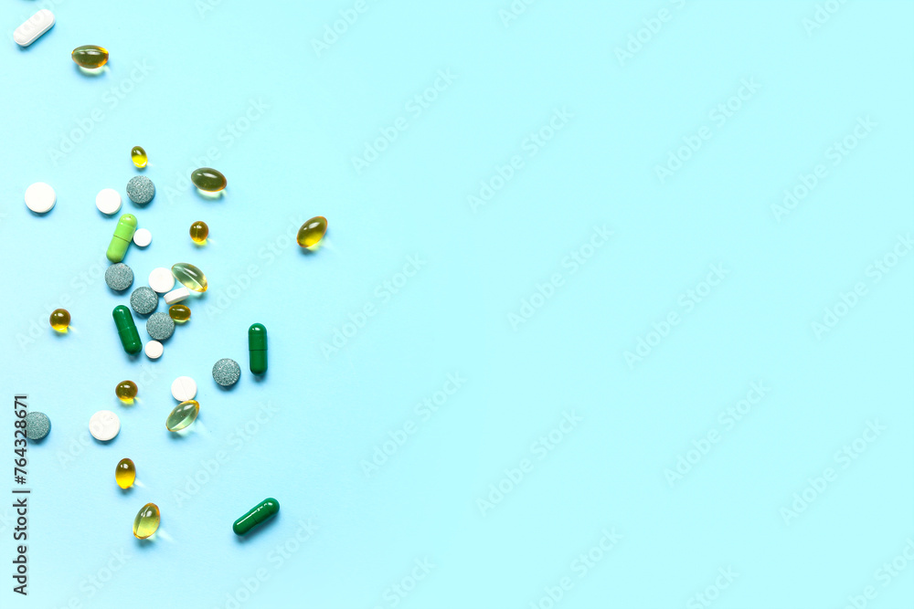 Fish oil capsules and different pills on blue background