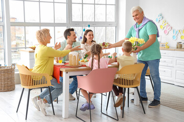 Wall Mural - Mature man bringing salad for Easter dinner with his family in kitchen