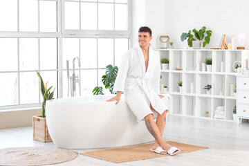 Sticker - Young man sitting on bathtub in bathroom