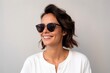 Portrait of a happy young woman in sunglasses on a gray background