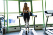 © Marino Bocelli - young blond woman running in sportswear on the treadmill in a gym