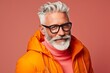 Portrait of a stylish senior man in orange jacket and eyeglasses.