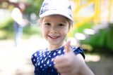 Fototapeta  - Happy young girl showing thumb up