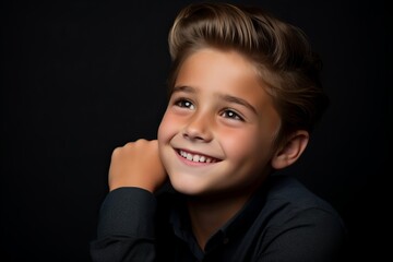 Portrait of a cute little boy on a dark background. Studio shot.