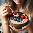 Woman's hands holding a berry oatmeal bowl – a healthy vegetarian breakfast