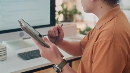 Cropped shot of male coder testing software application on PC and using digital tablet at desk