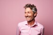 Happy senior man in pink shirt. Isolated on pink background.