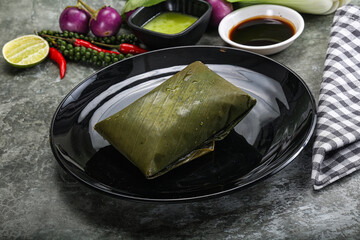 Wall Mural - Asian cuisine - rice with filling in banana leaf