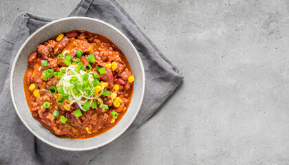 Canvas Print - beef chili. top view of homemade beef chili con carne with green onion garnish on grey bowl, copy space