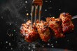 Fork with pieces of delicious barbecued meat on black background