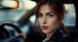 young attractive woman sitting at steering wheel in car and looking into camera - topic driving license and novice driver
