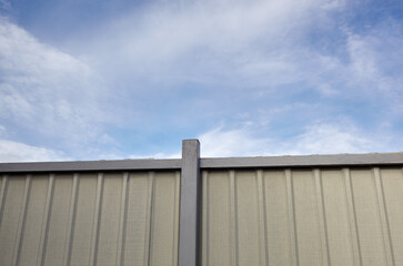 Wall Mural - Corrugated steel fence against blue sky. Corrugated metal texture surface or galvanize steel