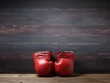 A pair of red boxing gloves rest against a natural wood wall