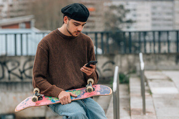 Sticker - young man on the street with mobile phone and skateboard